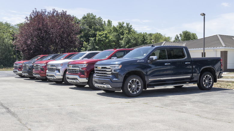 Six Chevy Silverado pickups parked in cement lot