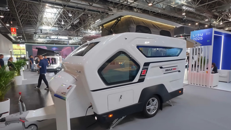 A white Aquila 360 mini camper at a show in Germany