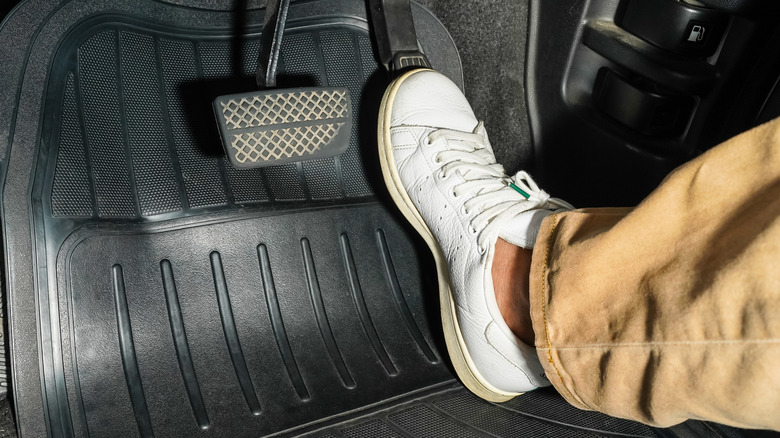 A driver pushing the accelerator to the floor