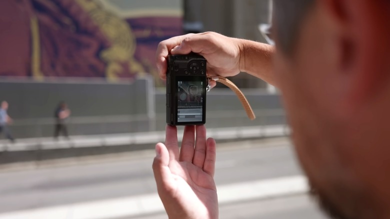 Person taking a photo using a Ricoh GR IV
