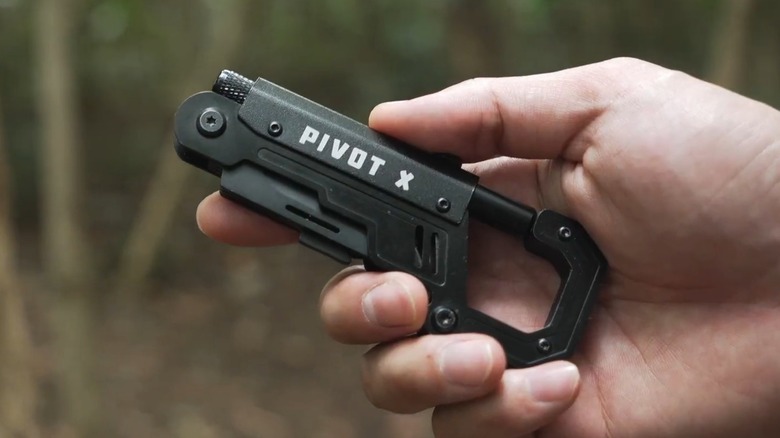 A person holding an Orioner carabiner multitool outside.