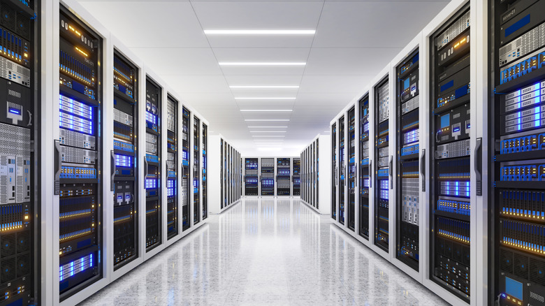 Inside a brightly lit modern data center with racks of servers on either wall