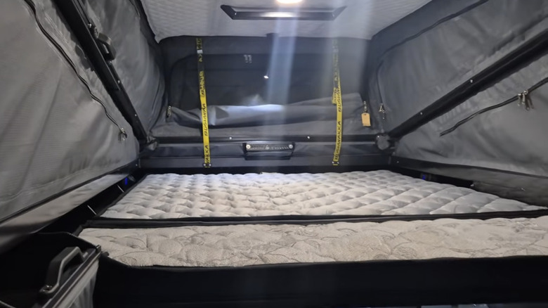 Video screenshot of additional bed in Bushwakka 4-sleeper Kamelback camper conversion