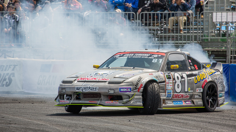 Front view of modified Nissan 180SX drifting at event in Japan.