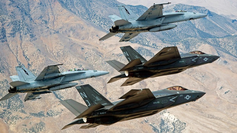 A pair of F-35Cs and F/A-18E/Fs flying over the desert