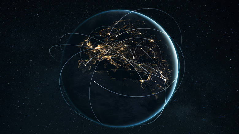 A night-time shot of the globe showing lights and internet connections around the world