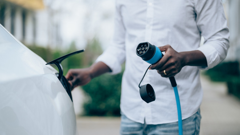 EV owner plugging in to charge their car