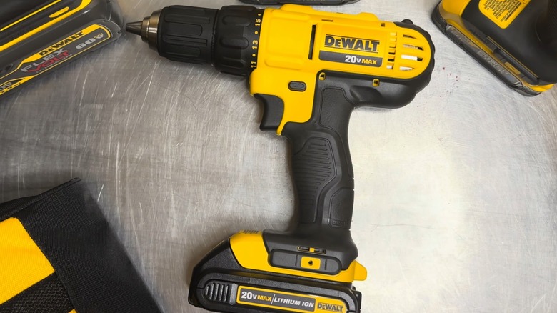DeWalt 20V Max 1/2-inch drill/driver on a steel surface surrounded by DeWalt batteries