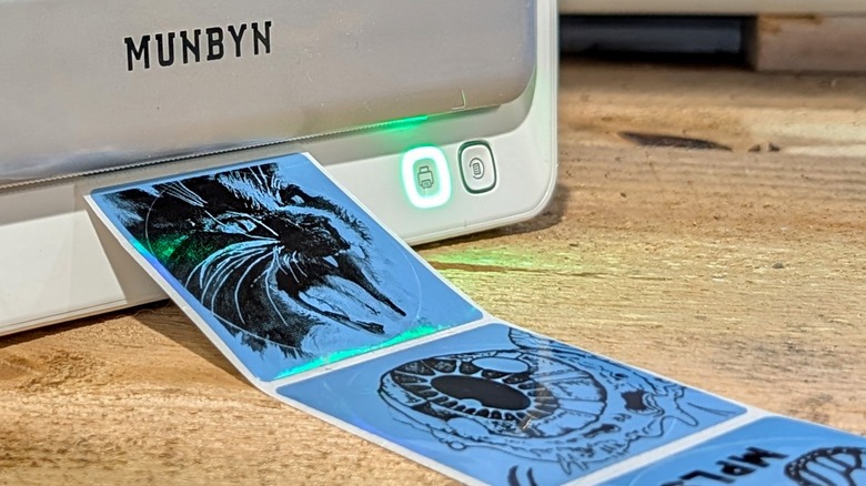 A Munbyn printer with several stickers on a wood surface.