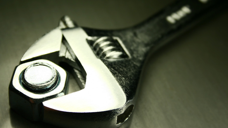 A adjustable crescent wrench tightening a bolt.