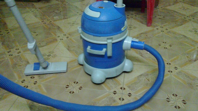 A vacuum cleaner on a tiled floor.