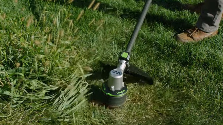 An EGO string trimmer working through taller grass without stopping with the Line IQ technology
