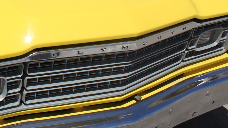 Close-up of Plymouth logo on the front of a yellow Plymouth Duster