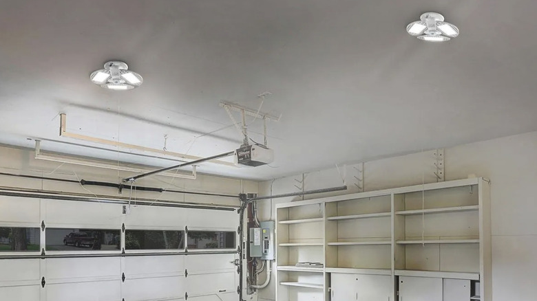 Two Braun 8000 Lumen Motion Sensor Shop Lights from Harbor Freight installed inside a garage with white walls and shelving