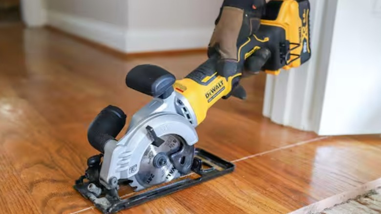 A DeWalt circular saw cutting through hardwood flooring