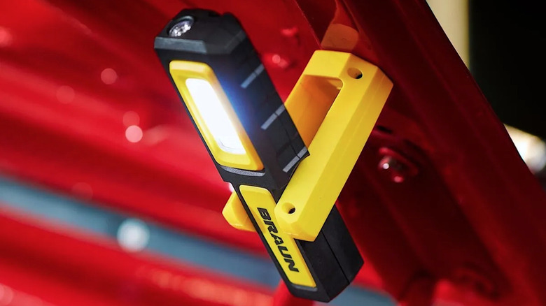 Magnets holding Braun LED light to a car's hood