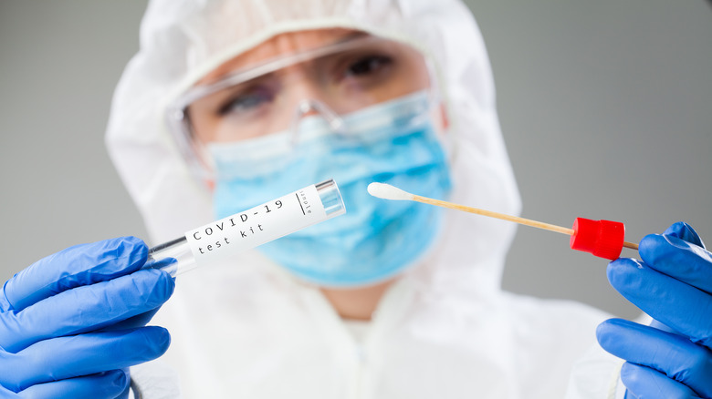Medical worker holding a nasal swab with COVID-19 test sample