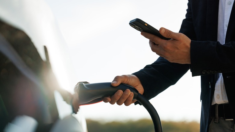 Somoeone checking smartphone at charging station