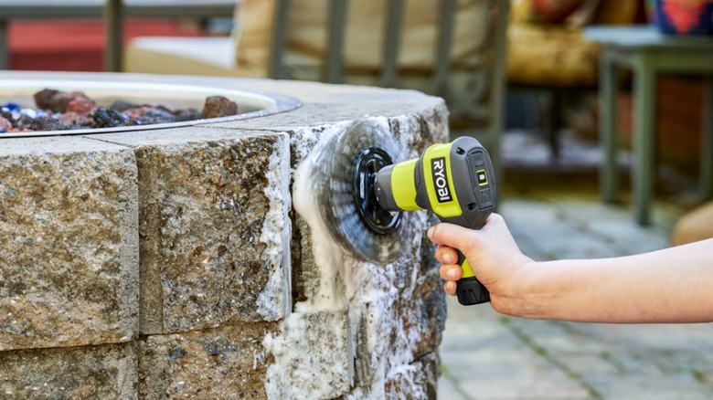 Ryobi USB Lithium Power Scrubber cleaning a patio fire pit