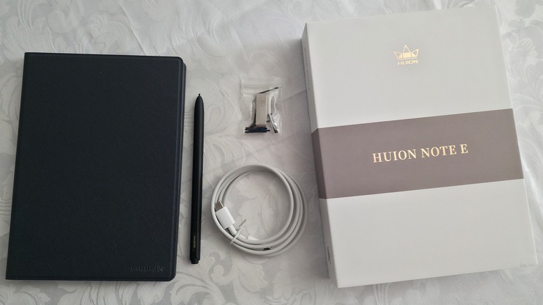 The Huion Note E with its accessories and box laid out on a white tablecloth