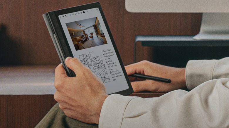 A man holding a Huion Note E and its pen