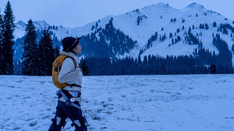 Woman wearing Hypershell exoskeleton in snowy, mountainous terrain