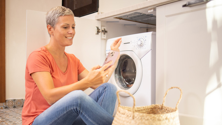 woman using iphone while laundering