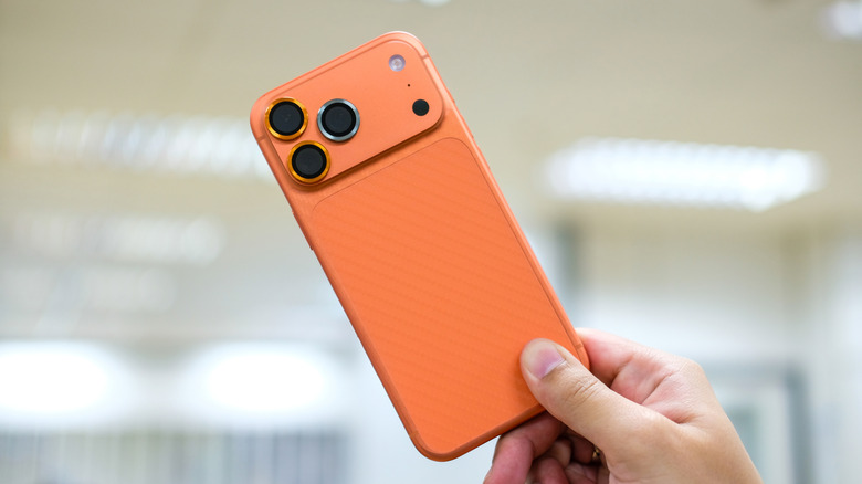 An iPhone 17 Pro Max in Cosmic Orange