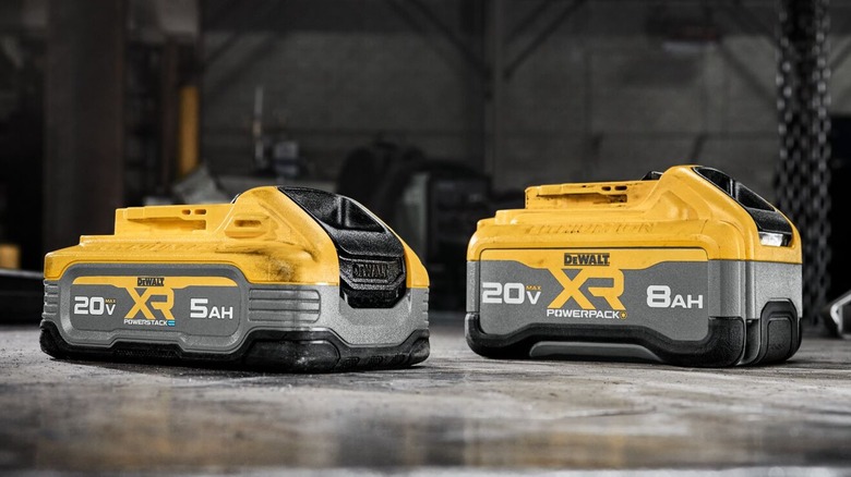 Two DeWalt batteries on a metal table.