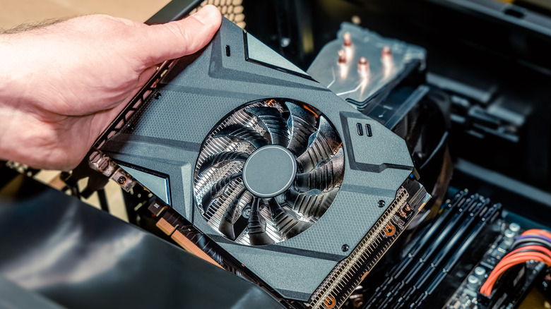 Installation of video card on a PC motherboard showing GPU with single cooling fan