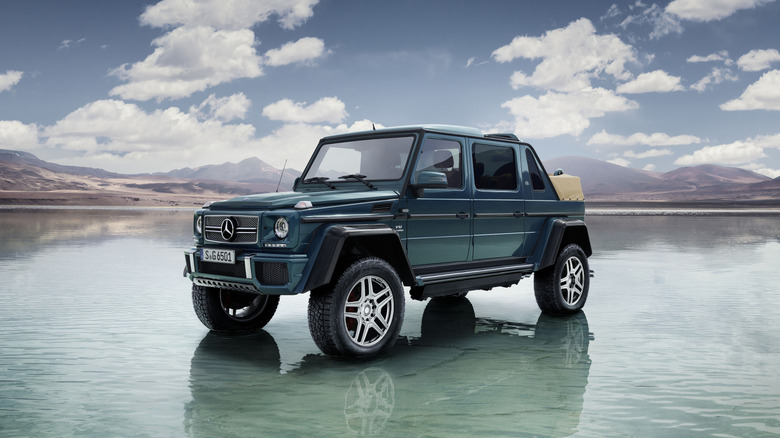 Front 3/4 view of a teal Mercedes-Maybach G650 Laundalet parked in some shallow water