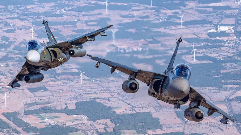 TTwo Indian Tejas fighters in close maneuvers over farmland