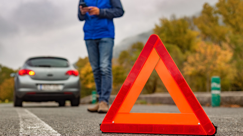 Person calling for roadside assistance with a mobile phone