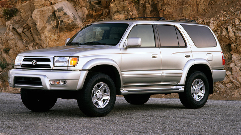 A 1999 Toyota 4Runner Limited parked on a paved surface with a cliff face in the background, front 3/4 view