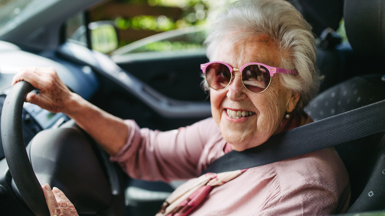 An older woman driver wearing sunglasses