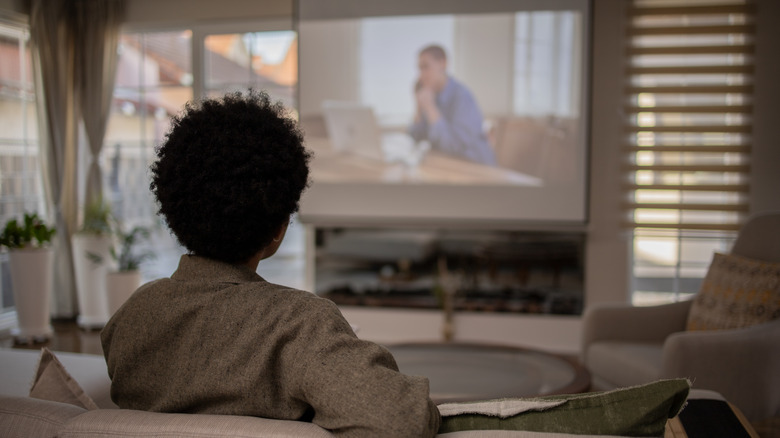 Person watching home projector