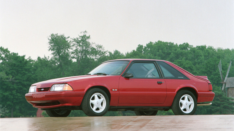 1992 Ford Mustang GT parked in front of wooded area, front-left 3/4 view