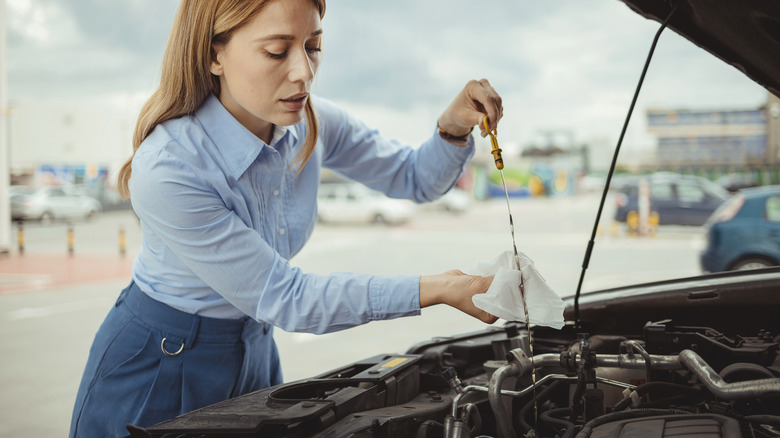 Driver check a car's oil dipstick