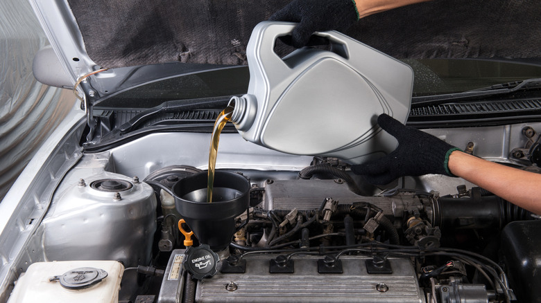 Technician changing a car's engine oil