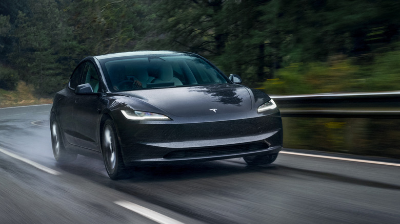 Gray Tesla Model 3 driving on a mountain road