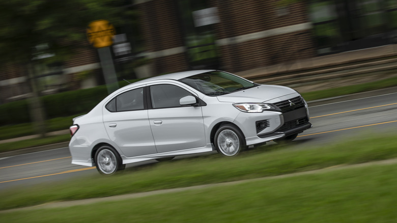 A Mitsubishi Mirage G4 in white on the move, front 3/4 view