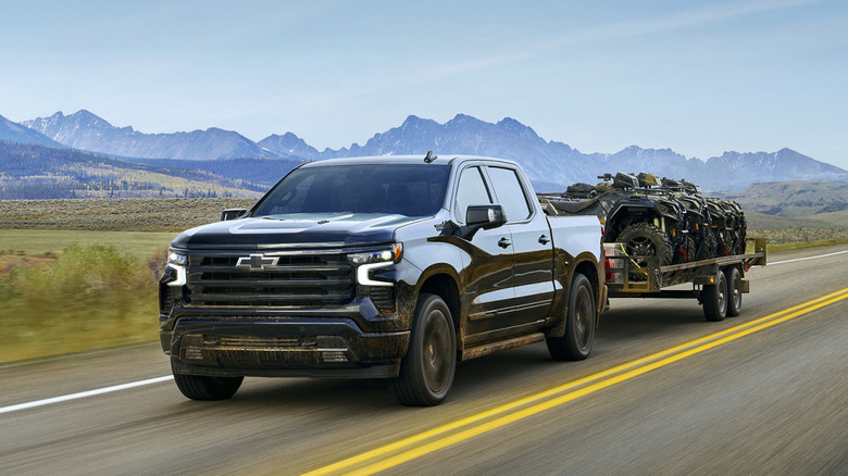 Black Chevrolet Silverado towing on an open road