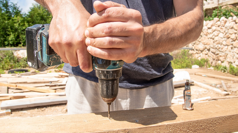 Person drilling into board