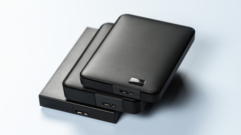 External drives lying on blue background. Reliability and functionality