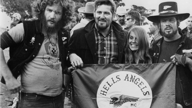 Sonny Barger with other Hells Angels members holding flag