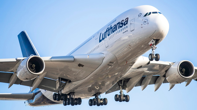 An Airbus A380 flown by Lufthansa in a blue sky.