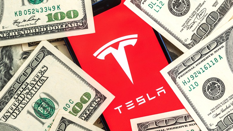 Tesla logo on smartphone with money