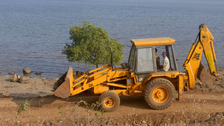 A image of a backhoe making its way down a dirt road