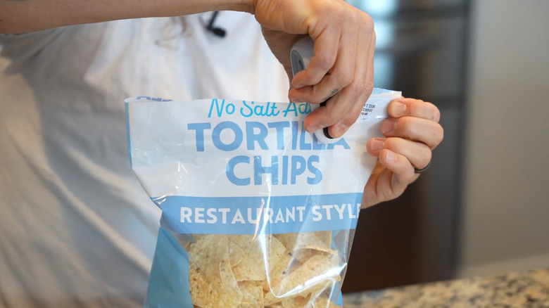 Bag of tortilla chips being resealed with handheld device