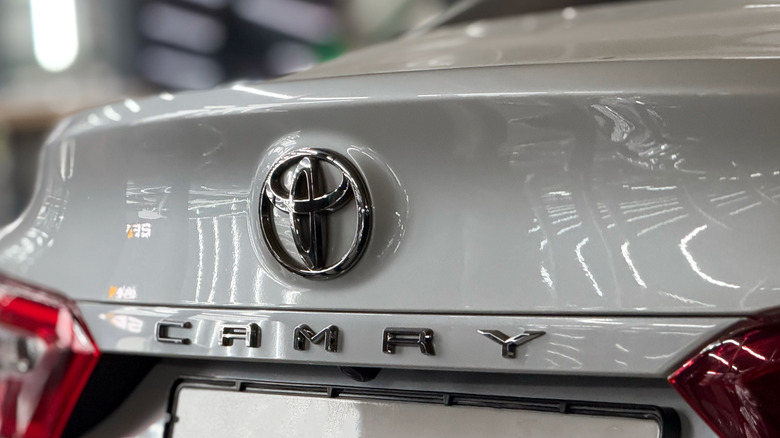 Stražnji dio bijele Toyote Camry s Toyotinim logotipom.